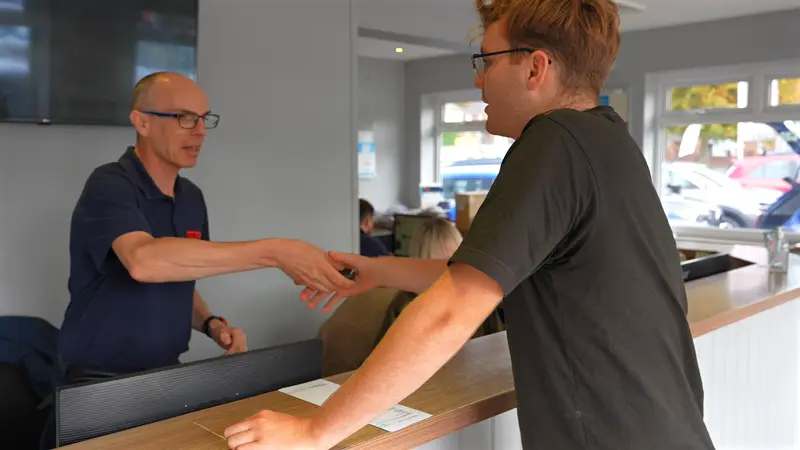 A Fairlee team member shaking hands with a customer at the reception desk
