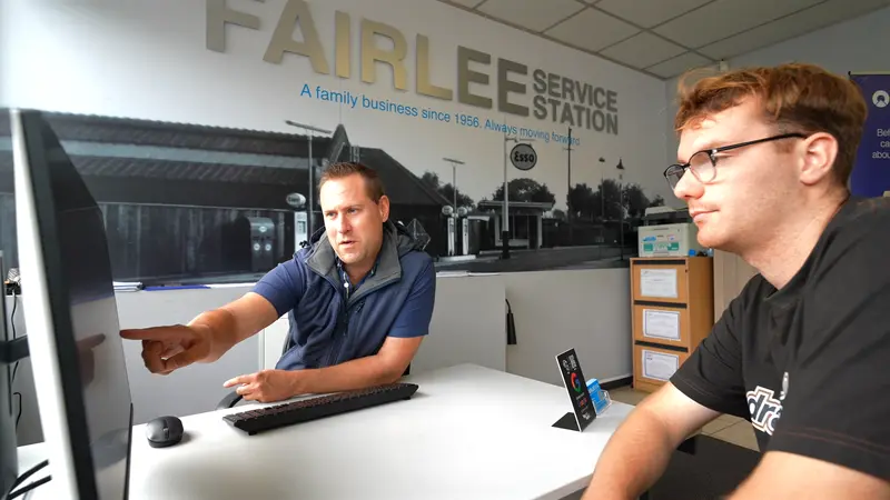 Two of the Fairlee team at a desk in the office, beneath a wall sign reading 'A family business since 1956'